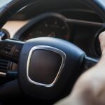 Detailed view of a car steering wheel with horn button in the center, emphasizing driver control and safety features.