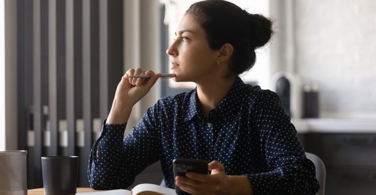 pensive girl, taking notes on what would be the best school between preply vs lingoda